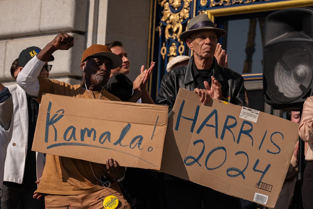 A group of people holding signs supporting Kamala Harris for President in 2024.